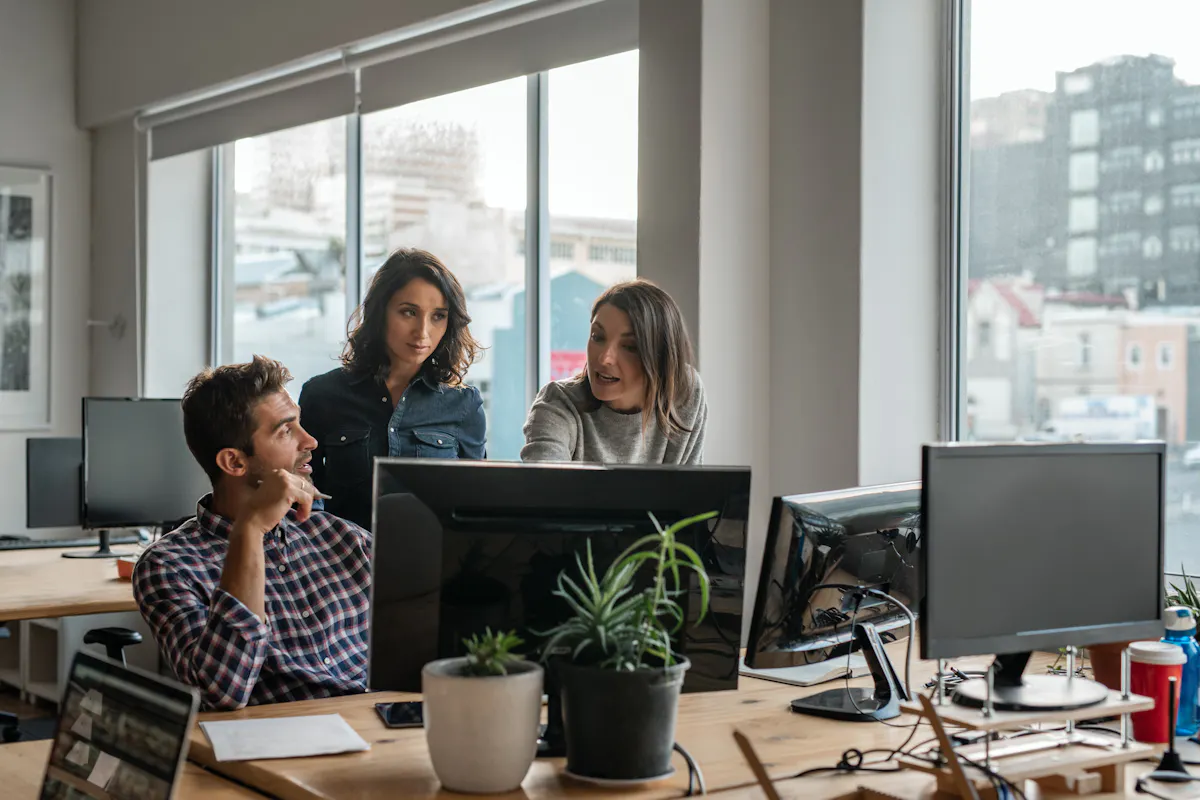 Two women and a man working to solve a tech problem
